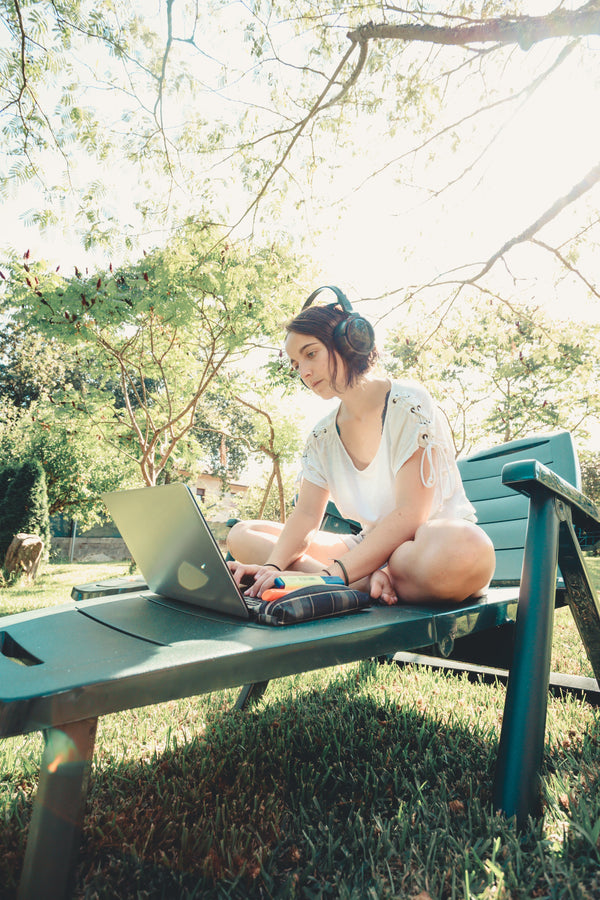 woman-works-on-her-laptop-outdoors-in-green-lawn-chair